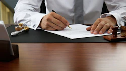 Signing Document In Office Adobe Stock Credit Africa Studio Resized