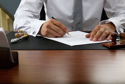 Signing Document In Office Adobe Stock Credit Africa Studio Resized