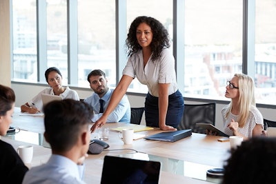 Woman Standing During Meeting Adobe Stock Credit Monkey Business Resized