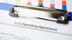 First page of an LLC operating agreement on a clipboard.