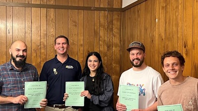 Greenleaf Compassionate Care Center workers in Portsmouth, R.I., stand with their newly ratified union contracts in hand.