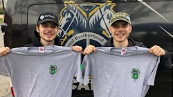 Two retail workers from Green Thumb’s RISE Colorado dispensary in Joliet, Ill., wear hats with the company’s banded logos while they hold up Teamster Local 777 union branded shirts following a vote to unionize in June 2022.