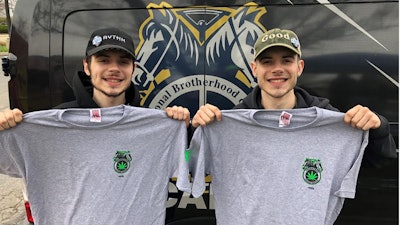 Two retail workers from Green Thumb’s RISE Colorado dispensary in Joliet, Ill., wear hats with the company’s banded logos while they hold up Teamster Local 777 union branded shirts following a vote to unionize in June 2022.
