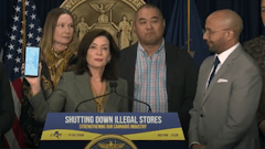 Gov. Kathy Hochul holds up a phone showing map locations of unlicensed cannabis shops in New York that appear in a search engine.