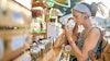 Two female tourists shopping for marijuana at a legal cannabis shop in Pattaya, Thailand, and smelling product.