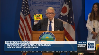 Ohio Gov. Mike DeWine shows how intoxicating hemp products can sometimes be packaged in manners similar to popular candies and snacks that entice children during an Oct. 8 press conference in Columbus.