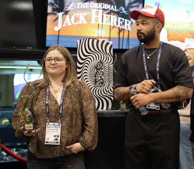 Green Rebates Director of Rebates Hannah Massey and VP of Partnerships Justin Hall accepting the award for 'Best Engaging Booth Activation' at MJBizCon 2024.