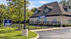 Ascend Dispensary brick building exterior with logo sign, black fence, and landscaping