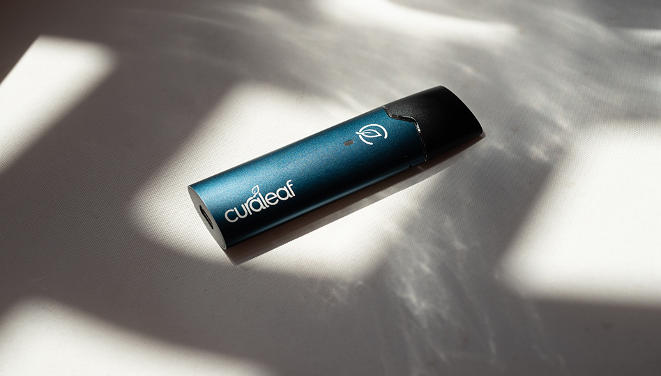 Curalear branded cylindrical device with teal finish and white logo symbol on white surface with shadows