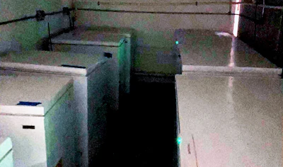 Overhead security camera view of industrial space with concrete floor, metal railings, and structures