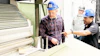 Workers in hard hats examining equipment in an industrial manufacturing facility