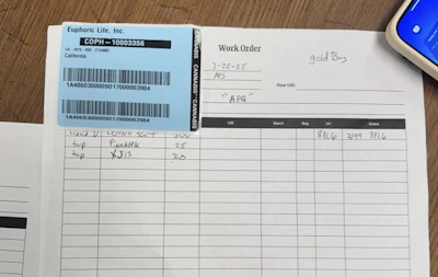 Euphoric Life, Inc. shipping label with barcode and work order form on wooden surface