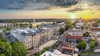 Aerial sunset view of downtown with golden-domed state capitol building surrounded by historic architecture and tree-lined streets along a river.