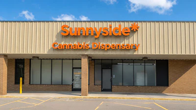 Sunnyside Cannabis Dispensary storefront with orange signage on brick building