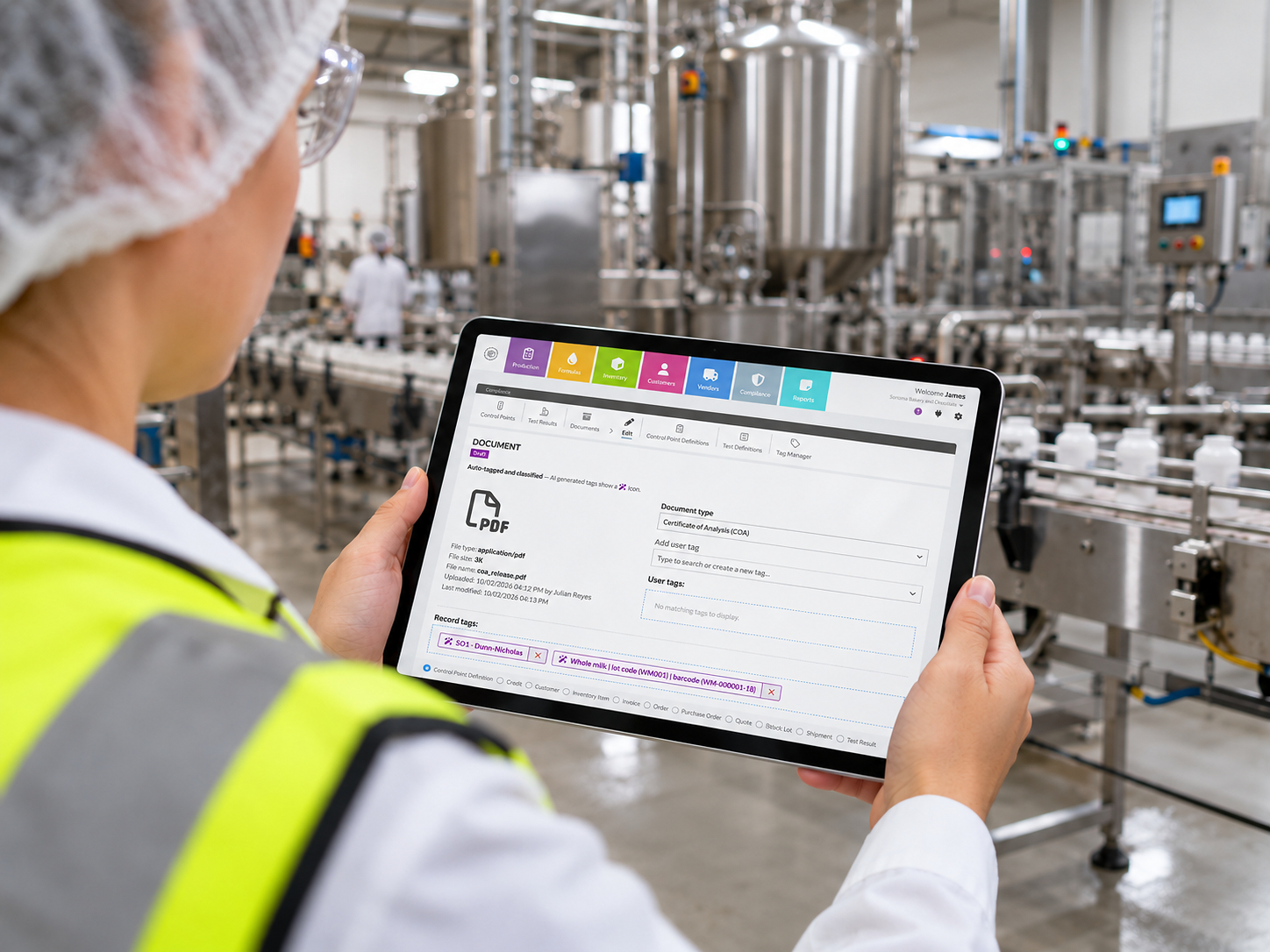 Factory worker in safety gear viewing software dashboard on tablet in industrial manufacturing facility