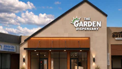 The Garden Dispensary storefront with modern tan facade, wooden accent awning, and glass doors in a retail plaza
