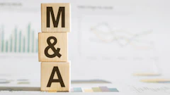Wooden blocks spelling M&A stacked on business documents with financial charts