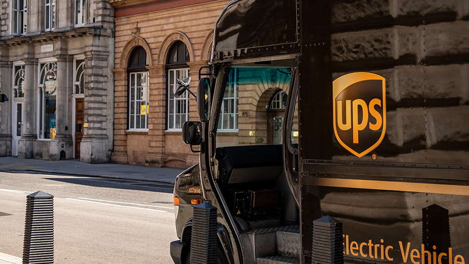 UPS electric delivery truck parked on a historic city street with the company's yellow shield logo visible on the vehicle's side