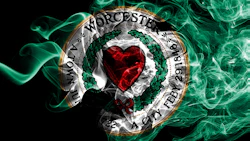 Worcester City Football Club circular emblem with red heart, green wreath, and gold border on black background