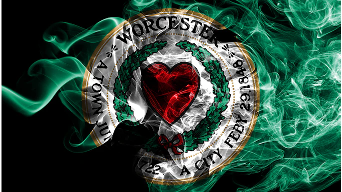 Worcester City Football Club circular emblem with red heart, green wreath, and gold border on black background
