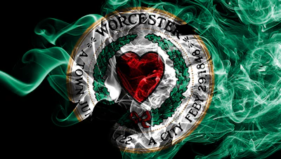 Worcester City Football Club circular emblem with red heart, green wreath, and gold border on black background